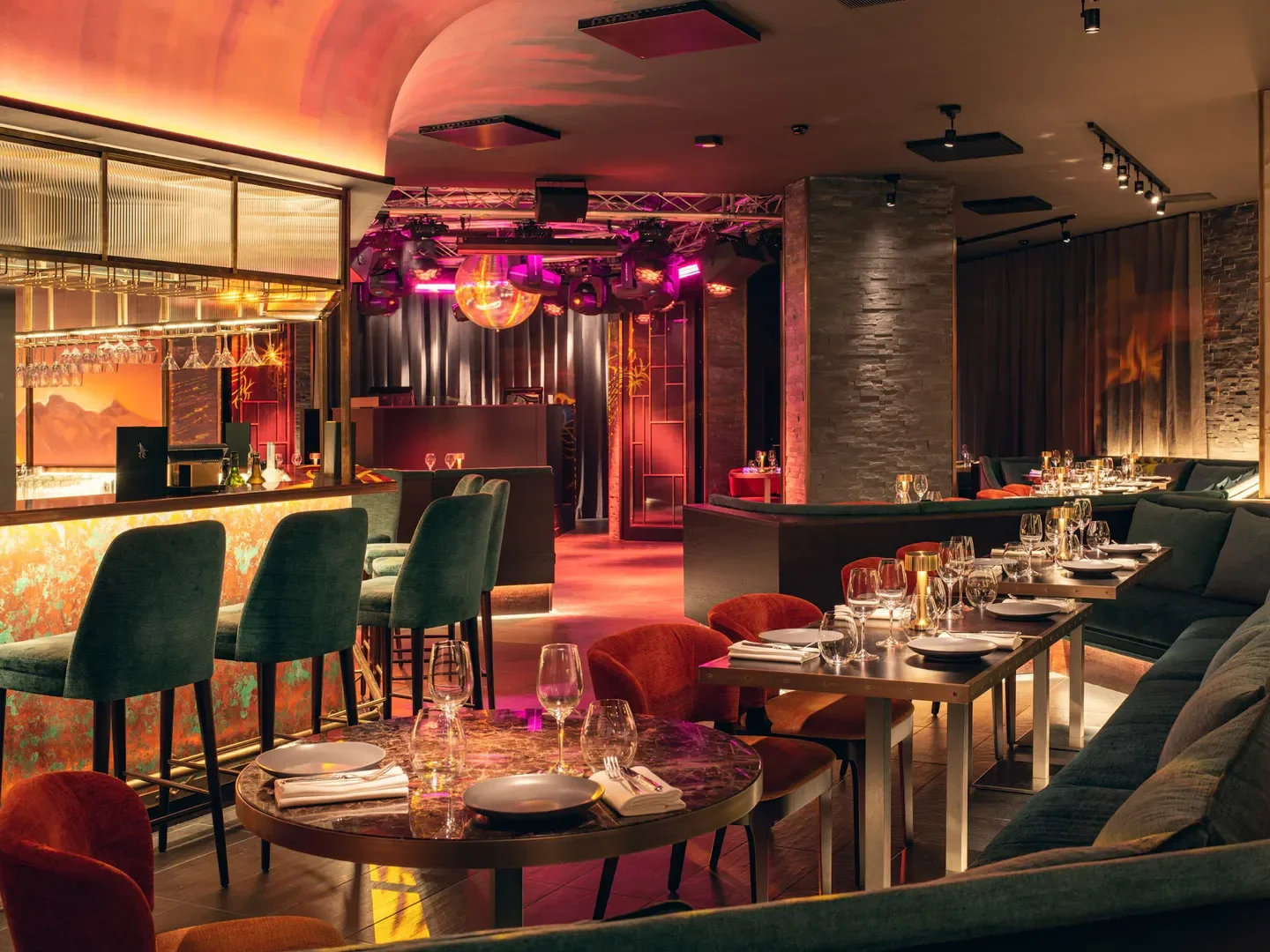 Interior of King's Social House in St. Moritz, featuring bar, tables, and a disco ball.