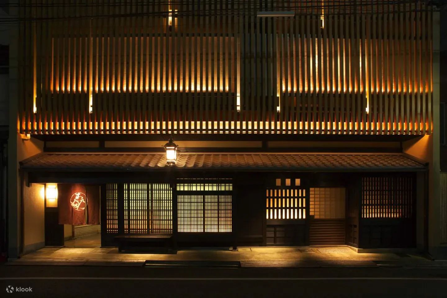 Kinobu restaurant exterior at night, Kyoto, with wooden facade and warm lighting.