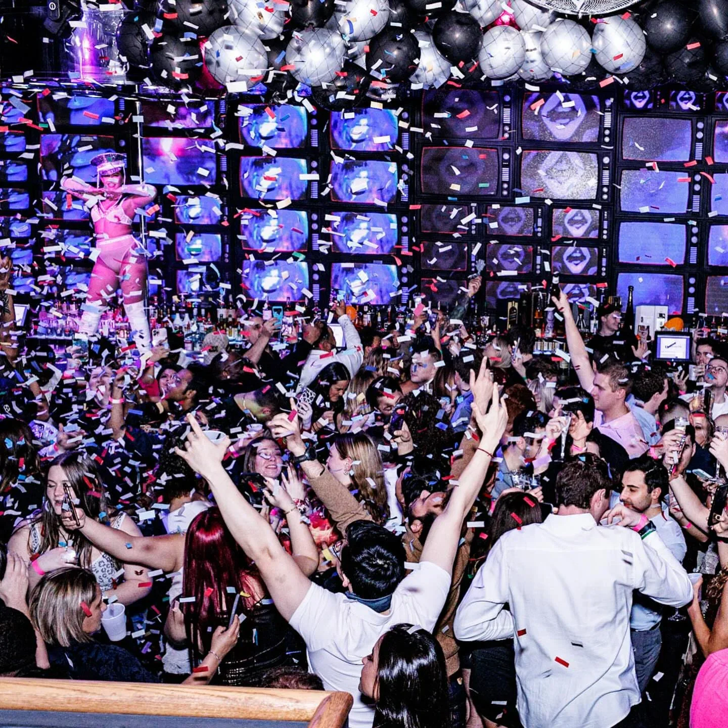 Confetti-filled party at Kiss Kiss nightclub in Atlantic City, with dancers and crowd.