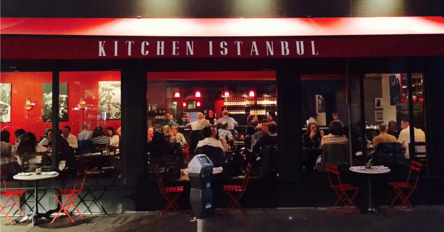 Exterior of Kitchen Istanbul restaurant in San Francisco with patrons dining inside.