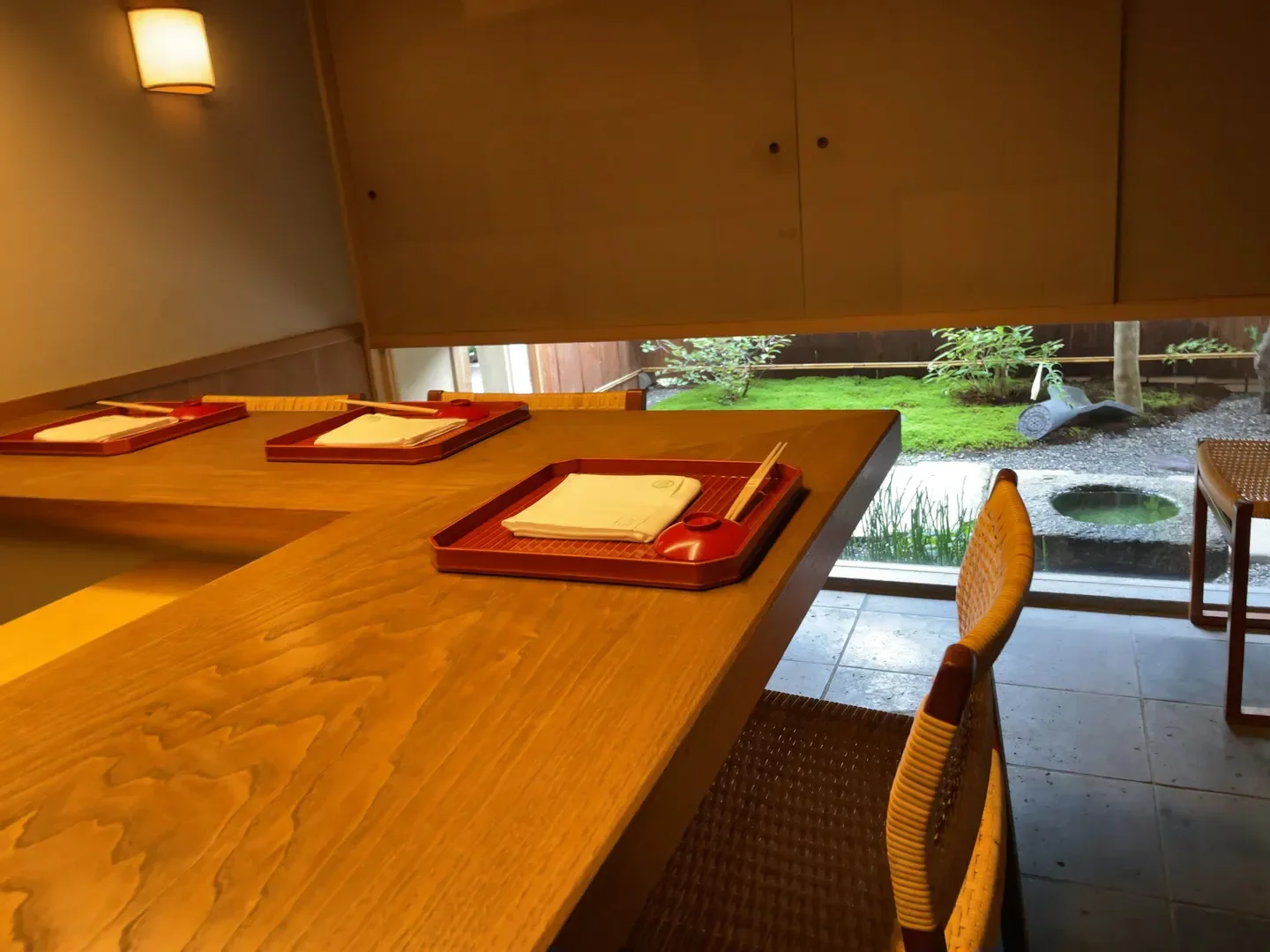 Interior dining at Kiyama restaurant in Kyoto with a view of a Japanese garden.
