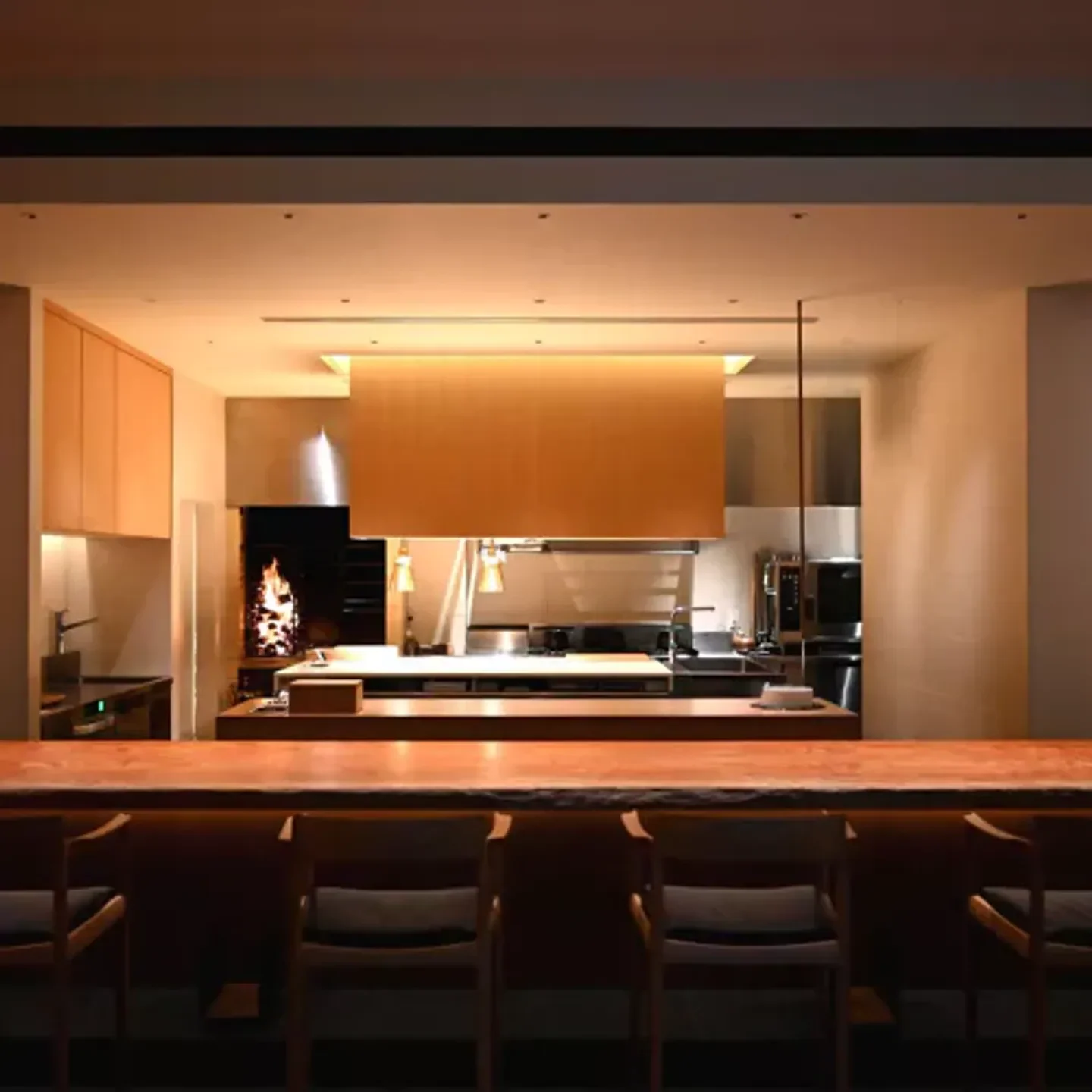 Interior view of KOKE restaurant in Kyoto, with wooden bar and open kitchen.