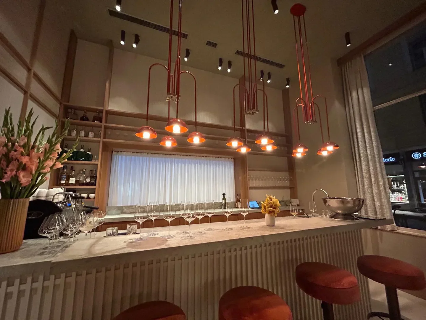 Interior of KOMU restaurant in Munich, featuring stylish bar and elegant lighting.