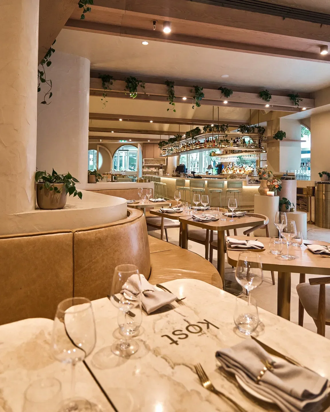 Interior view of KŌST restaurant in Gold Coast with elegant dining tables and bar.