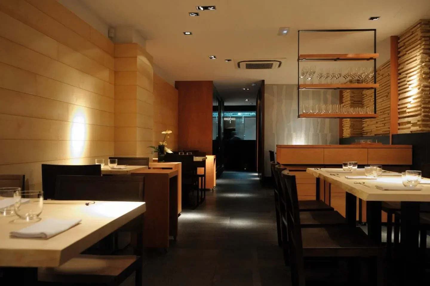 Elegant dining room interior at Koy Shunka restaurant in Barcelona with wooden decor
