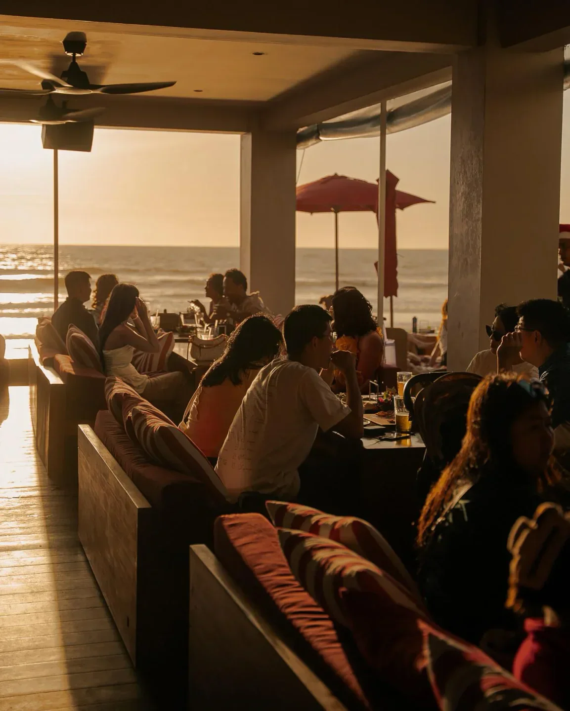 Sunset ambiance at KU DE TA Beach Club in Bali with ocean views and relaxed guests.