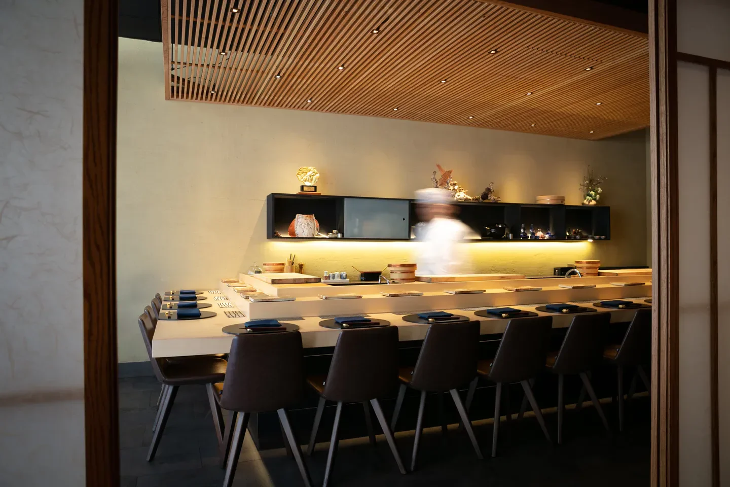 Interior view of KUSAKABE in San Francisco, with sushi bar and chef in motion.