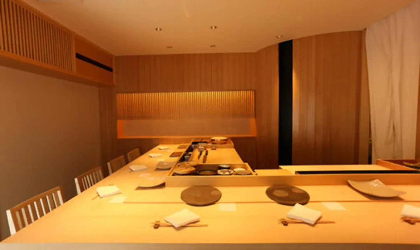 Interior view of Kutan restaurant in Tokyo, featuring a long sushi bar.