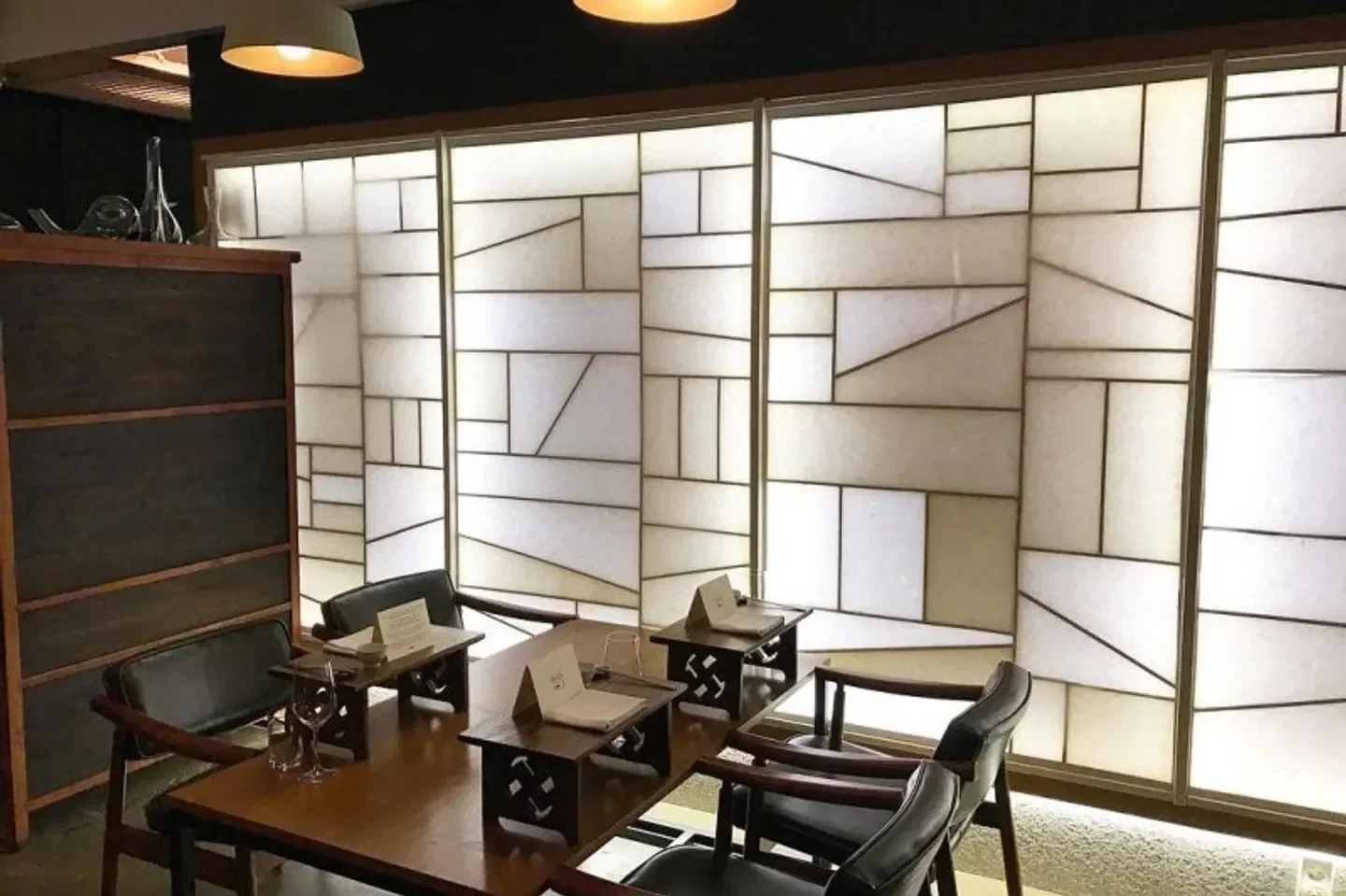 Interior of Kwonsooksoo in Seoul, featuring geometric walls and intimate dining tables.