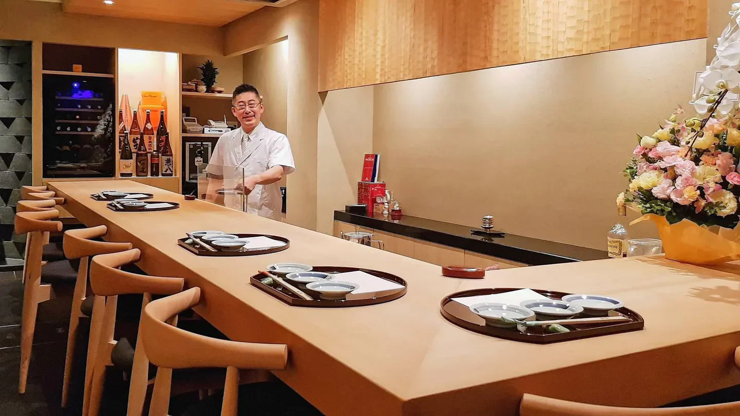 Interior of Kyoboshi restaurant in Kyoto, with chef and elegant sushi bar setup.