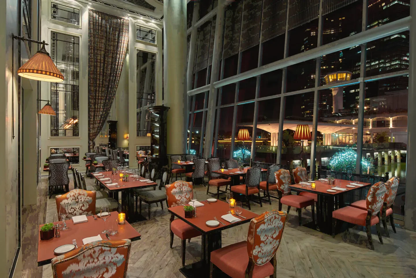 Elegant interior of La Brasserie restaurant in Singapore, with night city view.
