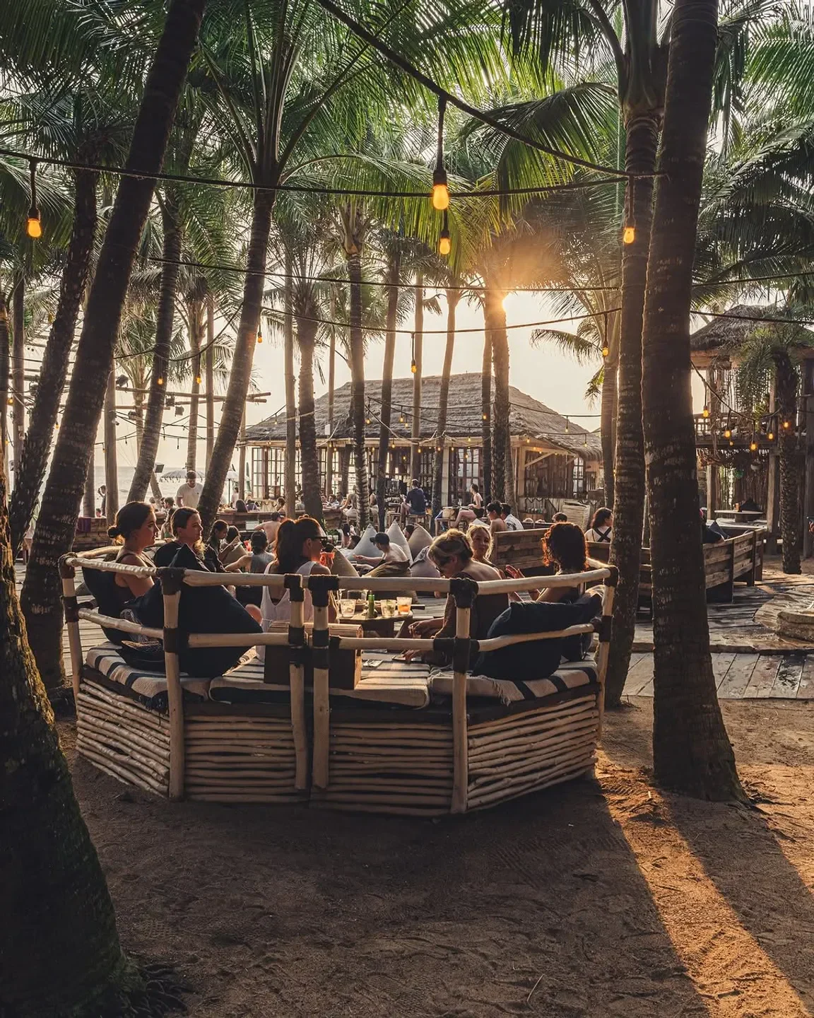 Dining at La Brisa Bali restaurant, surrounded by palm trees and warm sunset light.