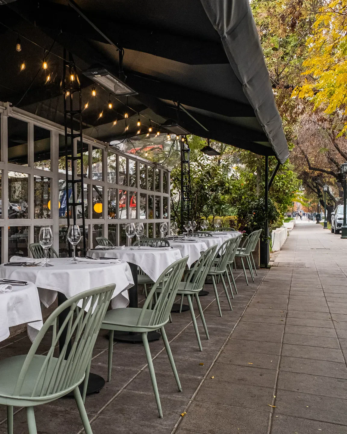 Outdoor seating at La Calma by Fredes restaurant in Santiago, Chile. Elegant dining on the sidewalk.