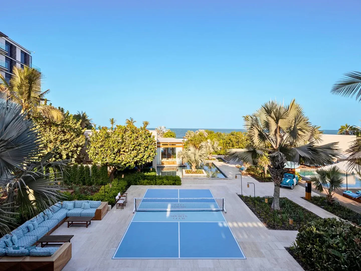 Outdoor lounge and pickleball court at La Cantine Beach resort with ocean views.