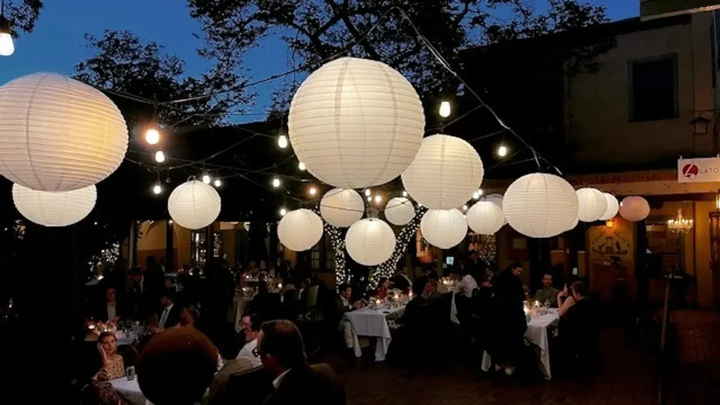Outdoor dining at La Casa Sena in Santa Fe, featuring paper lanterns and ambient lighting.