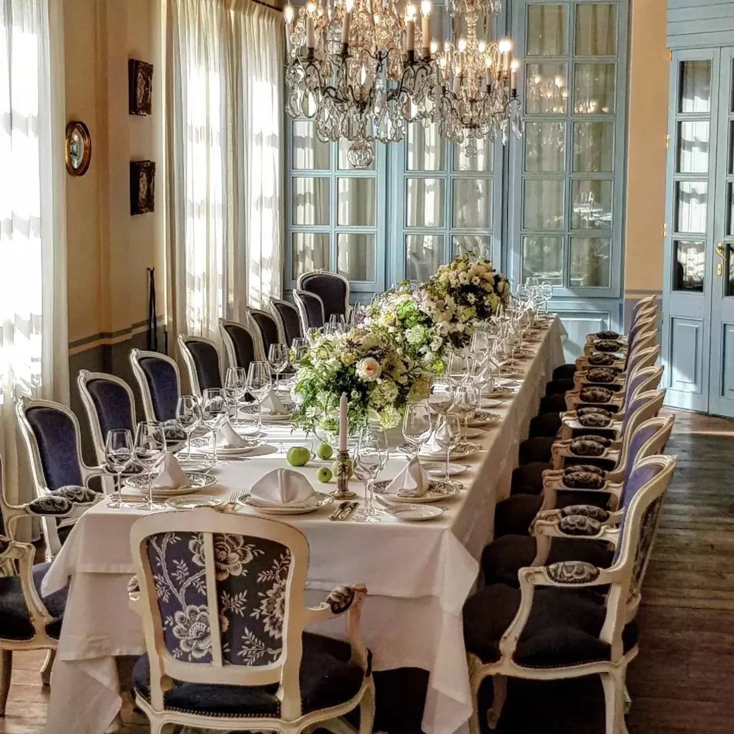 Elegant dining room at La Colline restaurant in Moscow, featuring a long table setting.