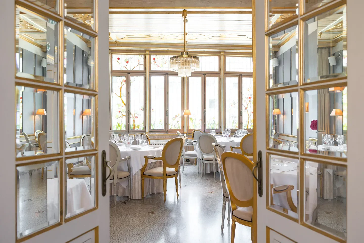 Elegant dining room at La Cristallerie restaurant in Luxembourg, seen through doorway