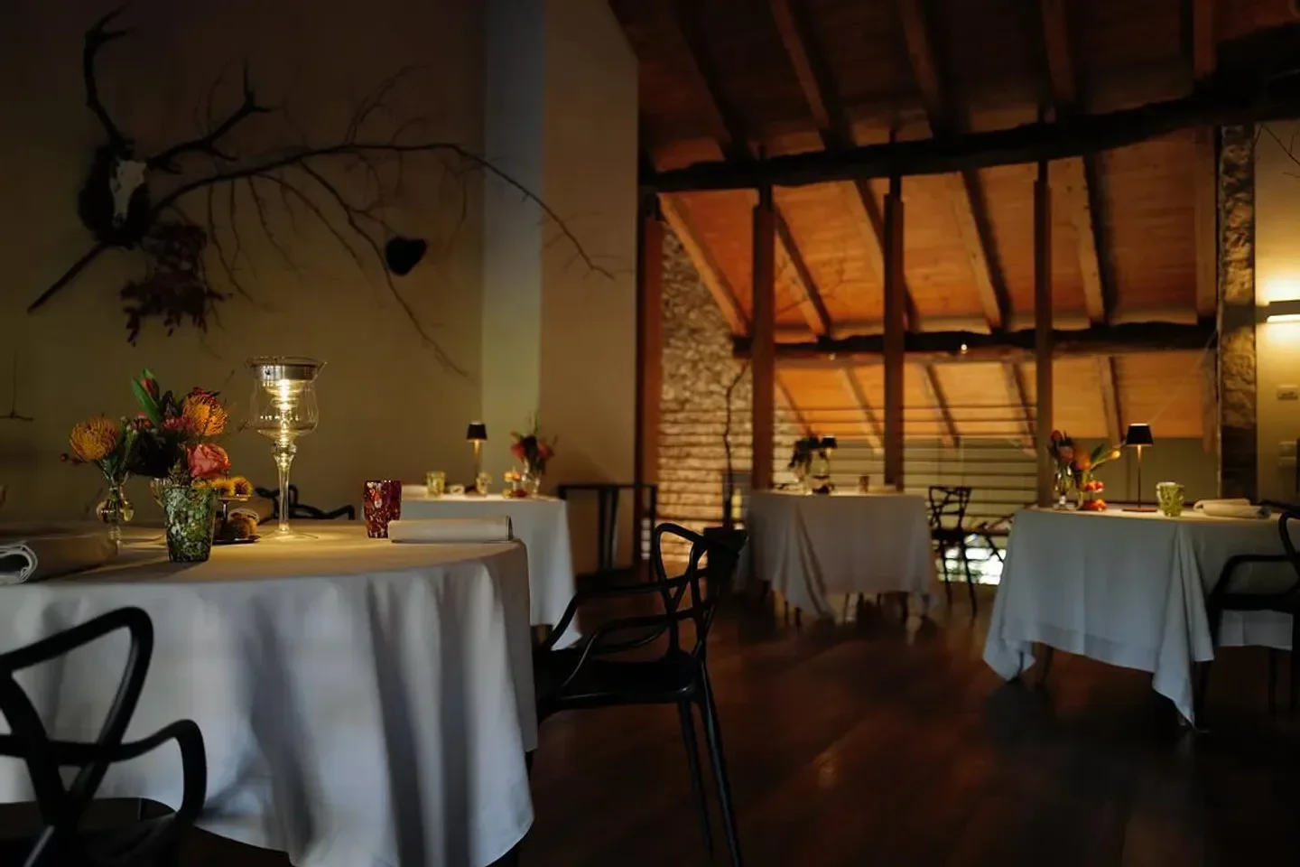 Elegant dining room interior at La Favellina restaurant in Veneto, with rustic decor and flowers