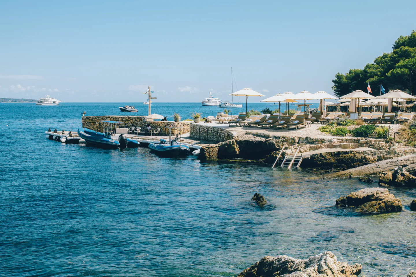 La Guérite beach club in Cannes with lounge chairs and yachts on a sunny day