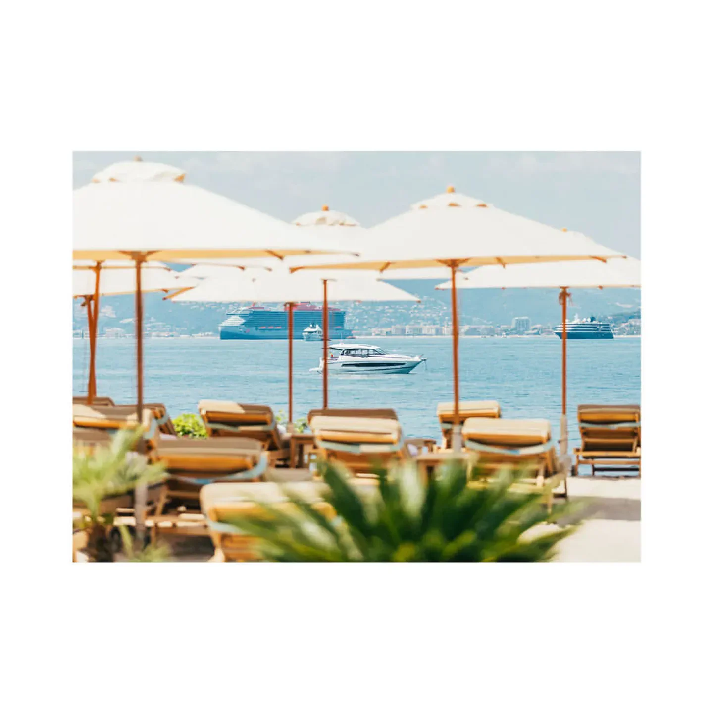 Relaxing beach scene at La Guérite restaurant in Cannes with boats and umbrellas.