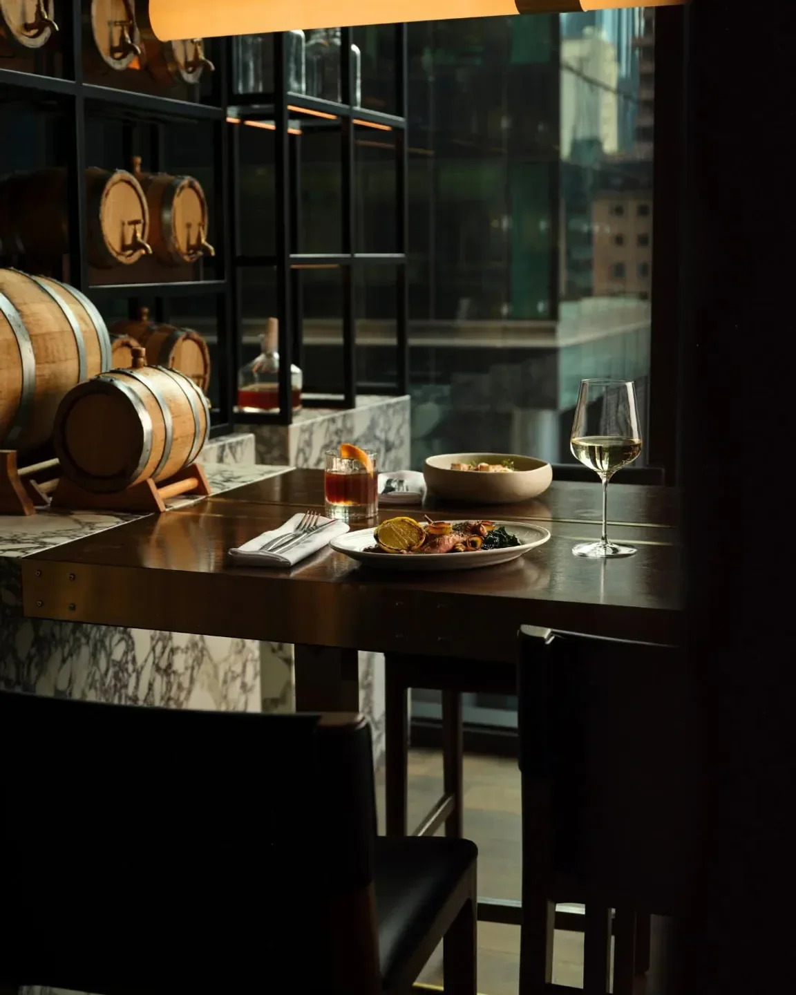 Dining scene at La Madonna restaurant in Melbourne, featuring food, drinks, and wine glasses.