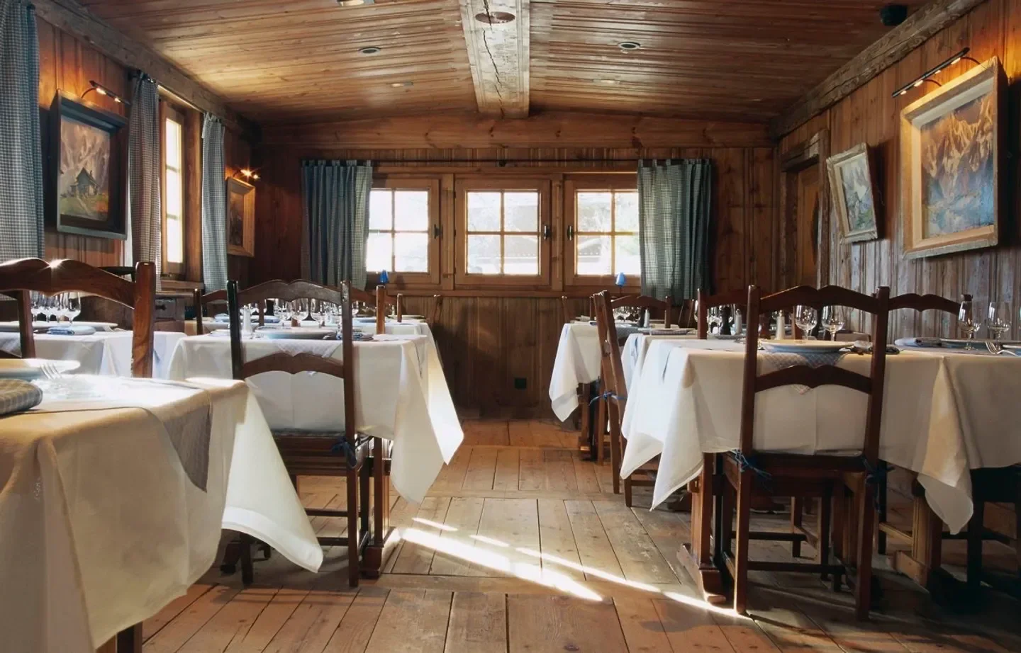 Cozy dining room at La Maison Carrier in Chamonix with wooden decor and set tables