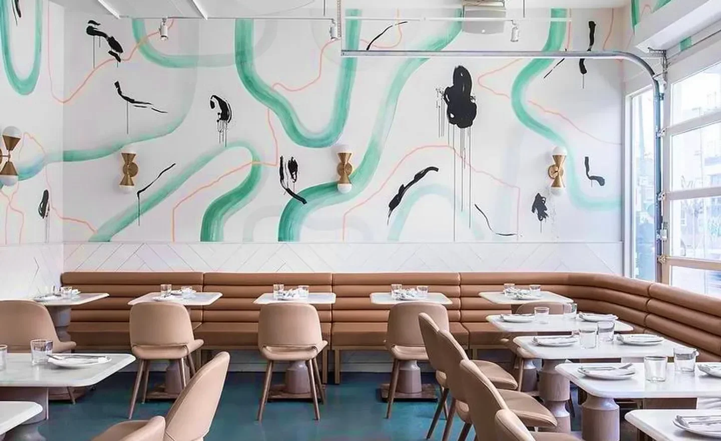 Interior of La Palma restaurant in Toronto, with stylish design and artistic mural on wall.