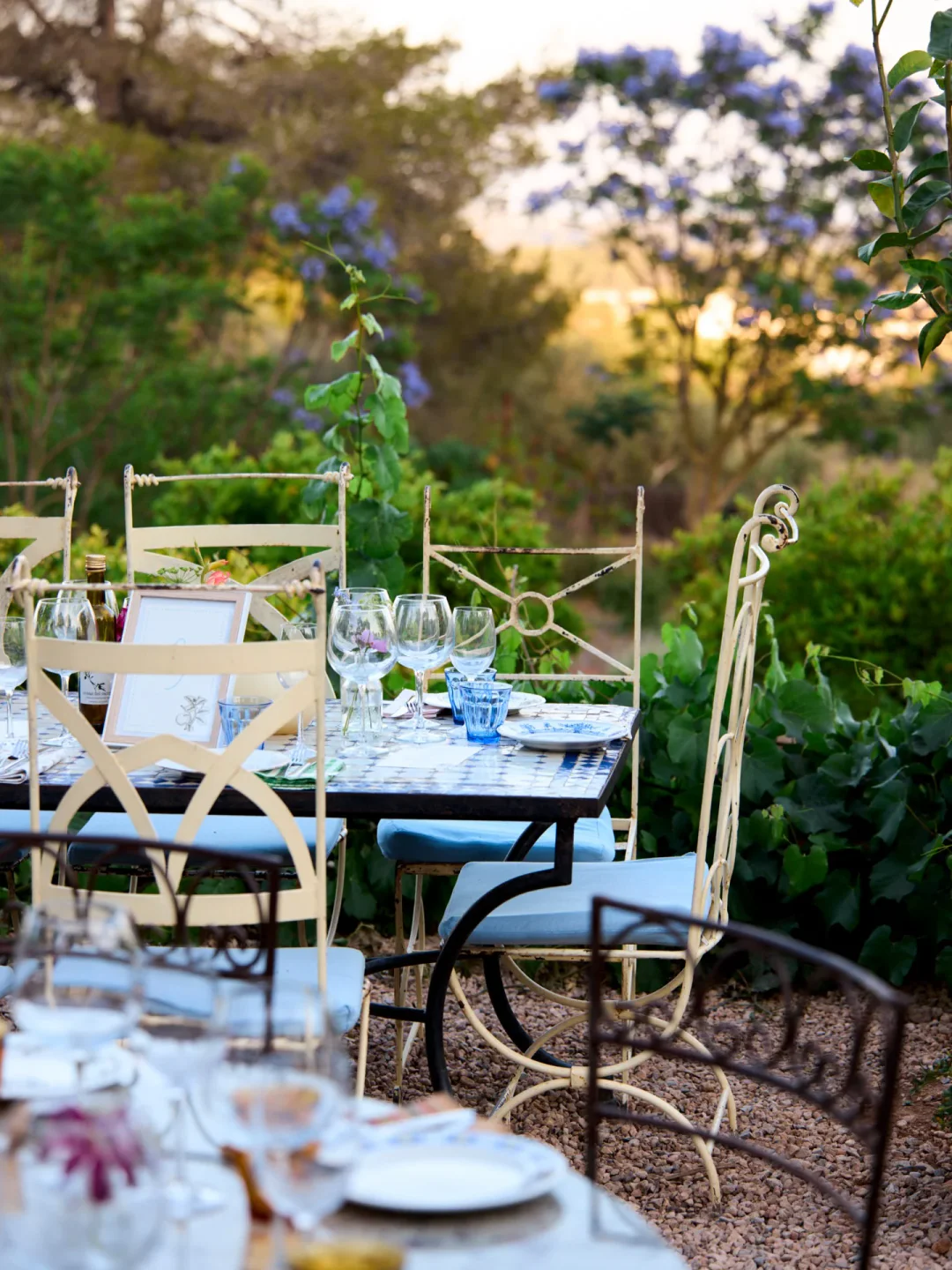 Outdoor dining setup at La Paloma restaurant with blue and white tiled tables and scenic garden views.