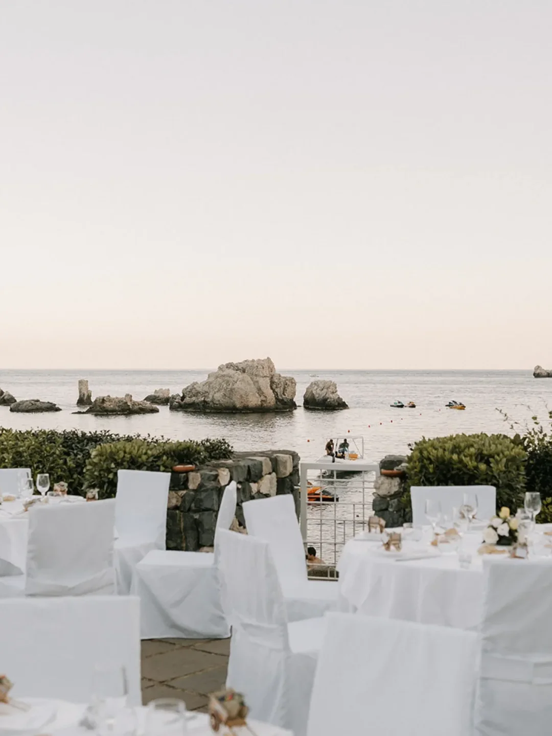 Elegant tables set for a beachside event at La Plage Resort Beach Club in Sicily overlooking the sea.