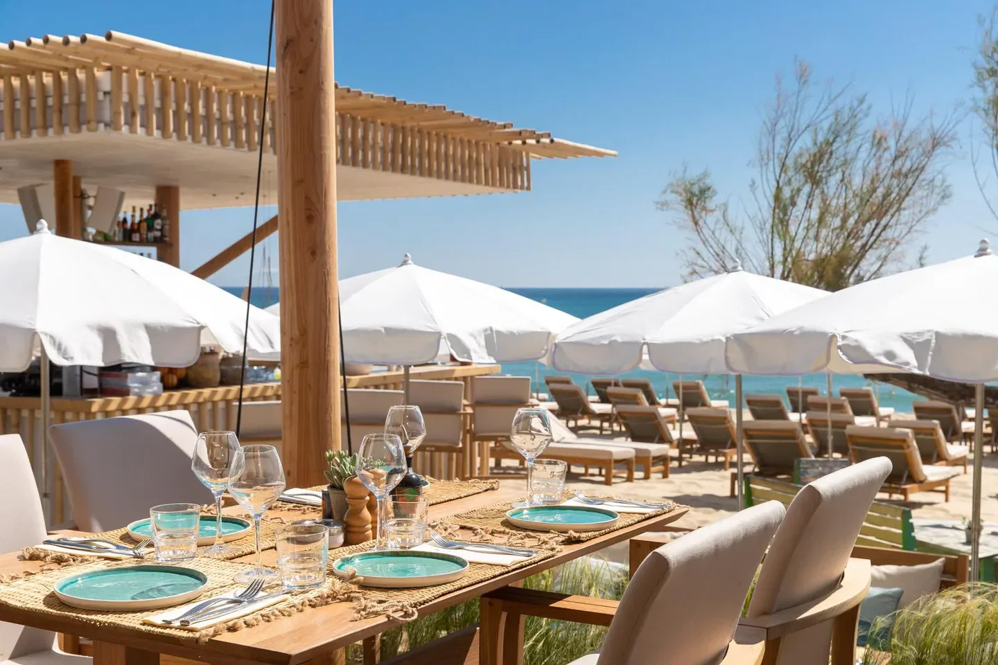 Dining experience at La Serena Beach restaurant in Saint-Tropez, with beach views and umbrellas.