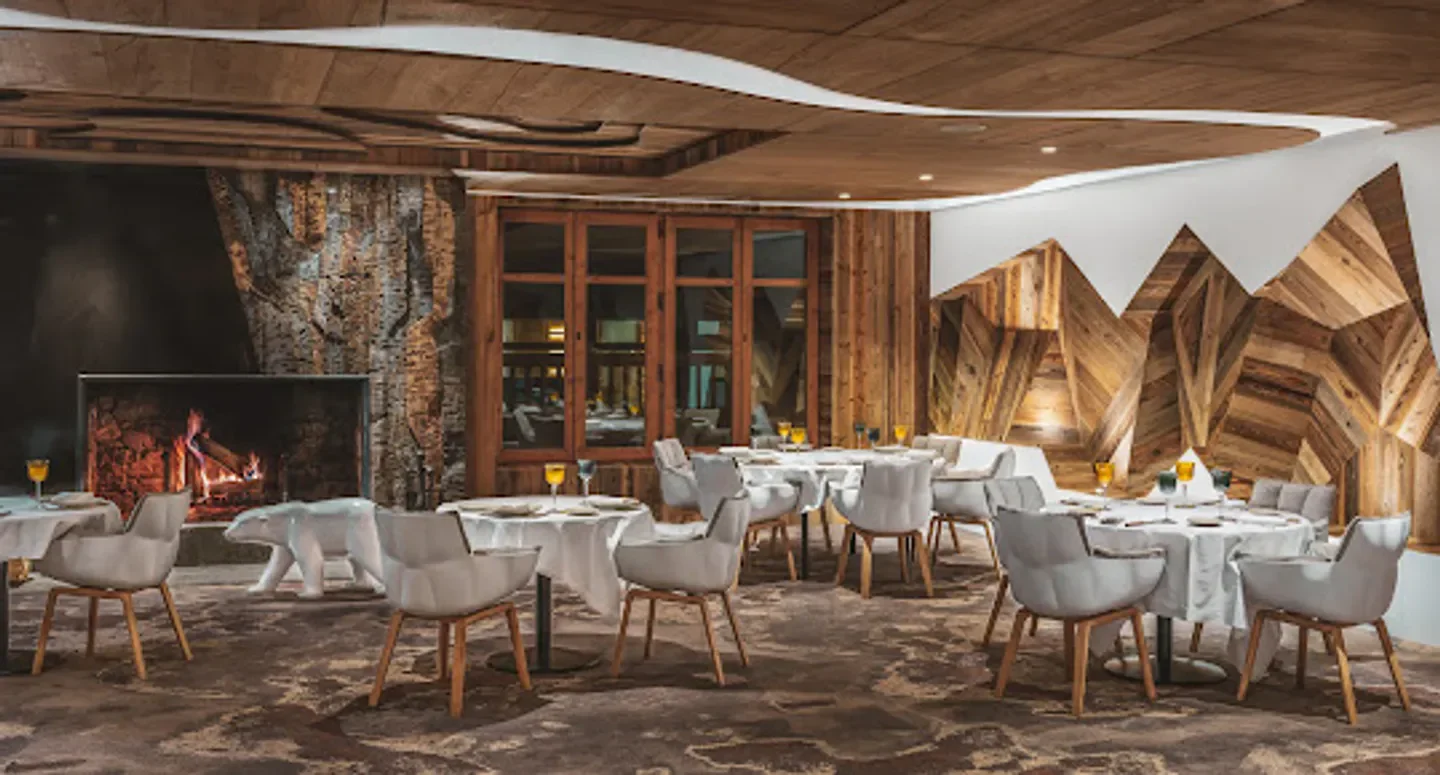 Cozy interior of La Table de l'Ours restaurant in Val-d'Isère, with fireplace and wooden decor