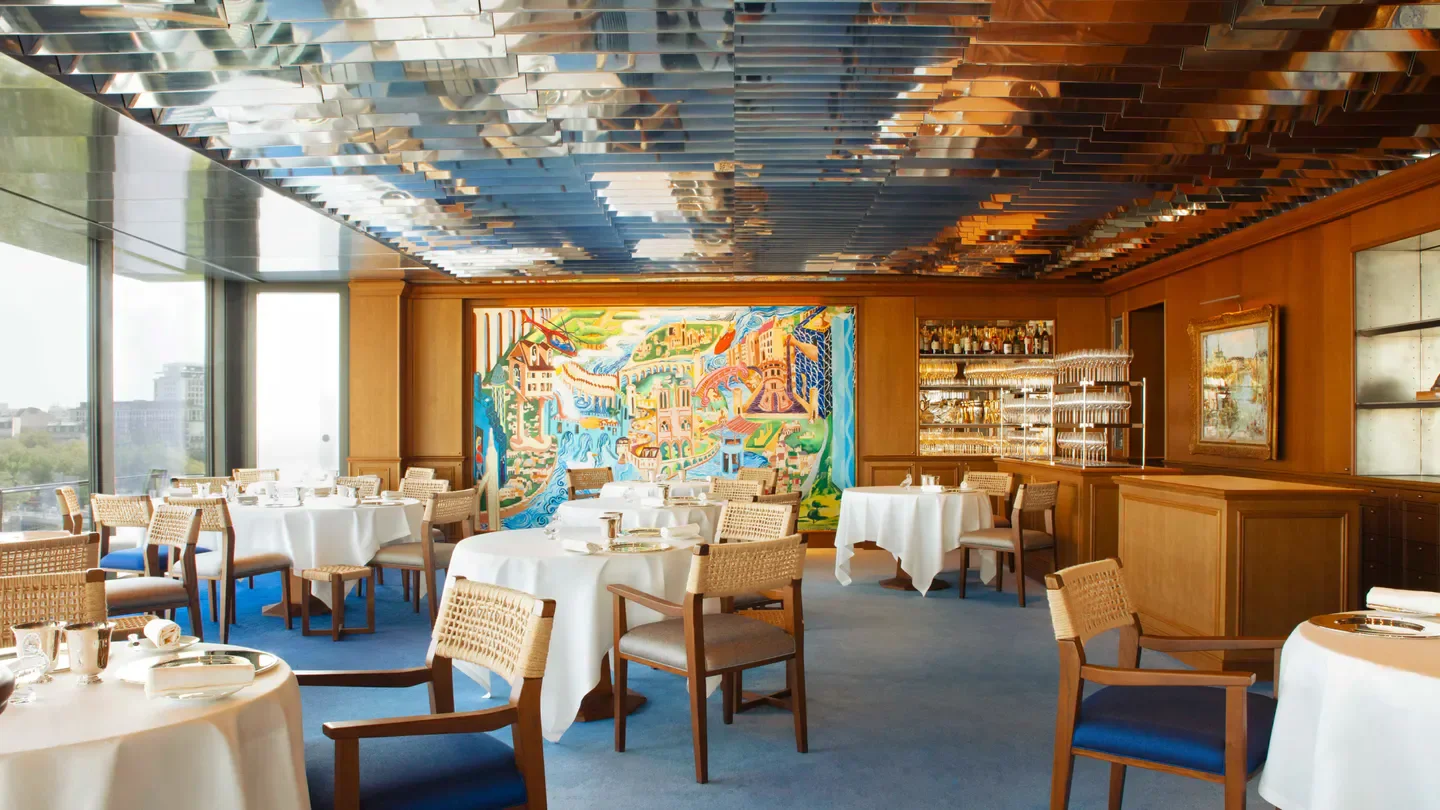 Interior dining room at La Tour d'Argent restaurant in Paris, featuring tables and art.