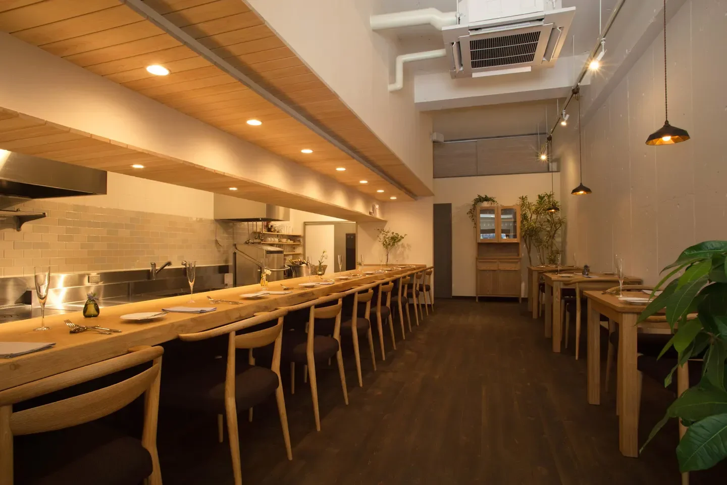 Elegant interior of LA TRACE restaurant in Nara, featuring long wooden tables and stylish decor.