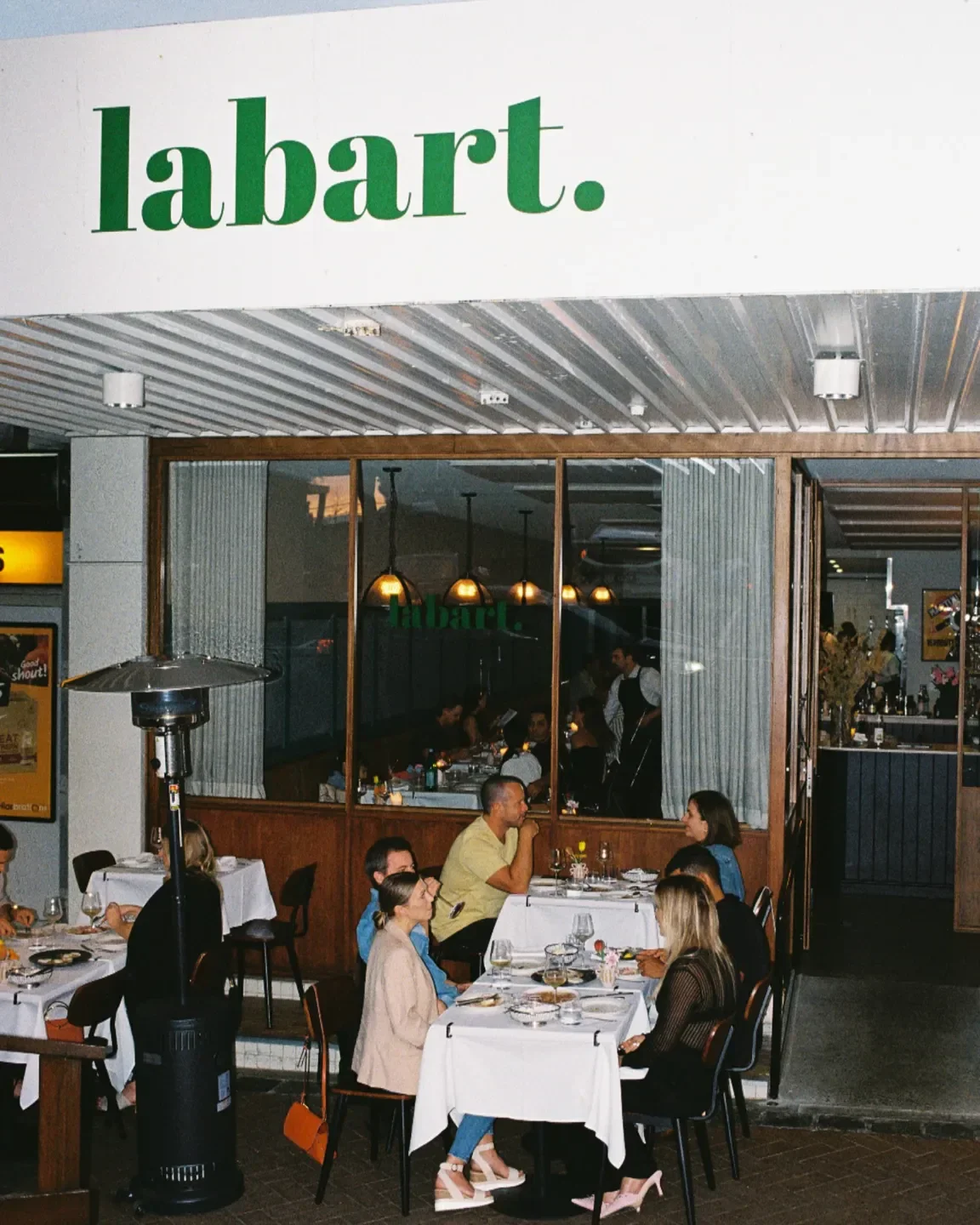 Outdoor dining at Labart restaurant in Gold Coast with patrons enjoying meals.