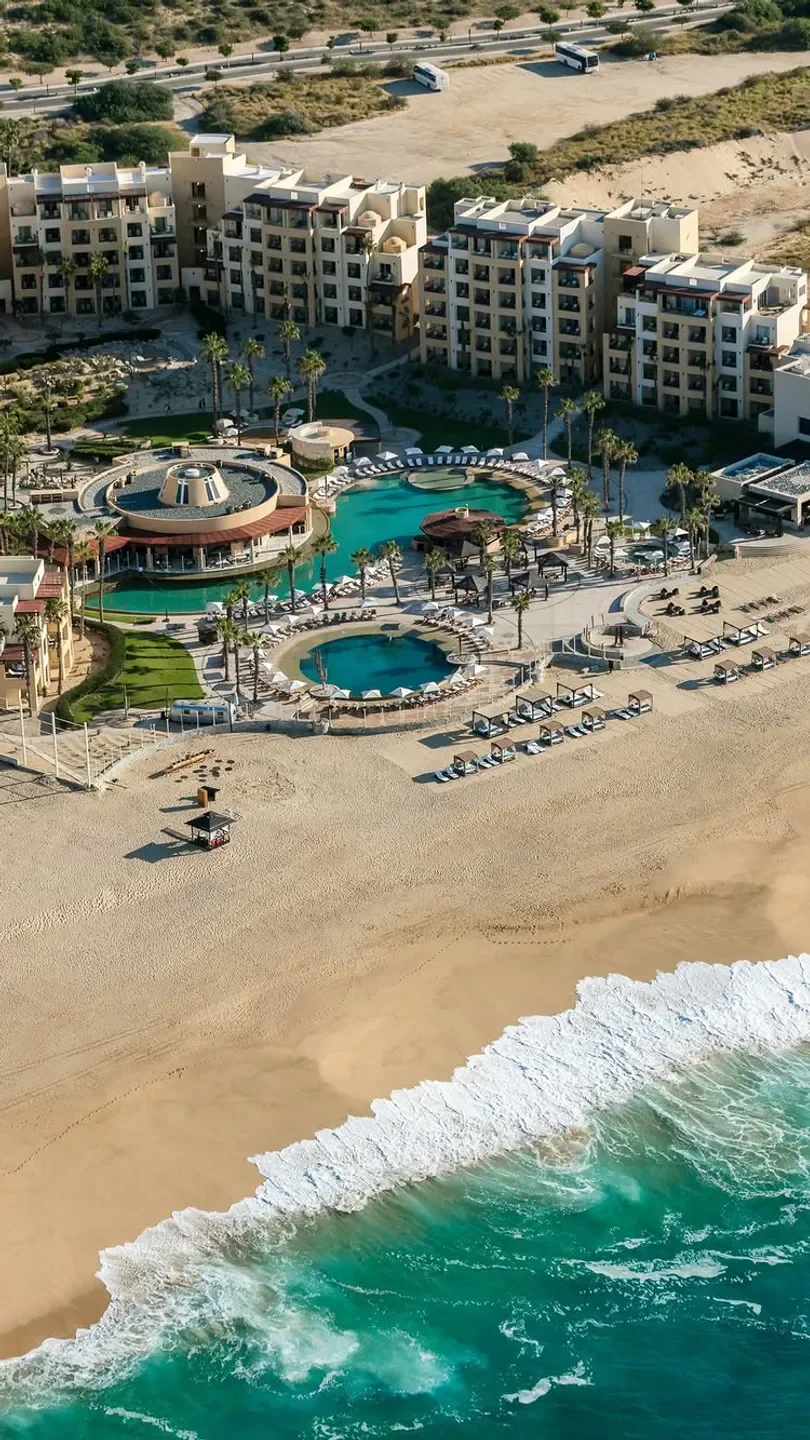 Aerial view of LaFrida Restaurant in Los Cabos, overlooking beach and pools.