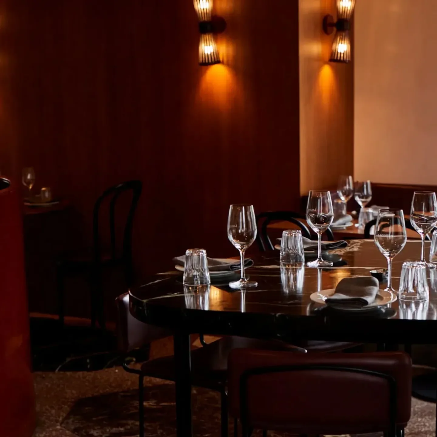 Elegant dining at Lagotto in Melbourne, featuring tables set with glassware and warm lighting.