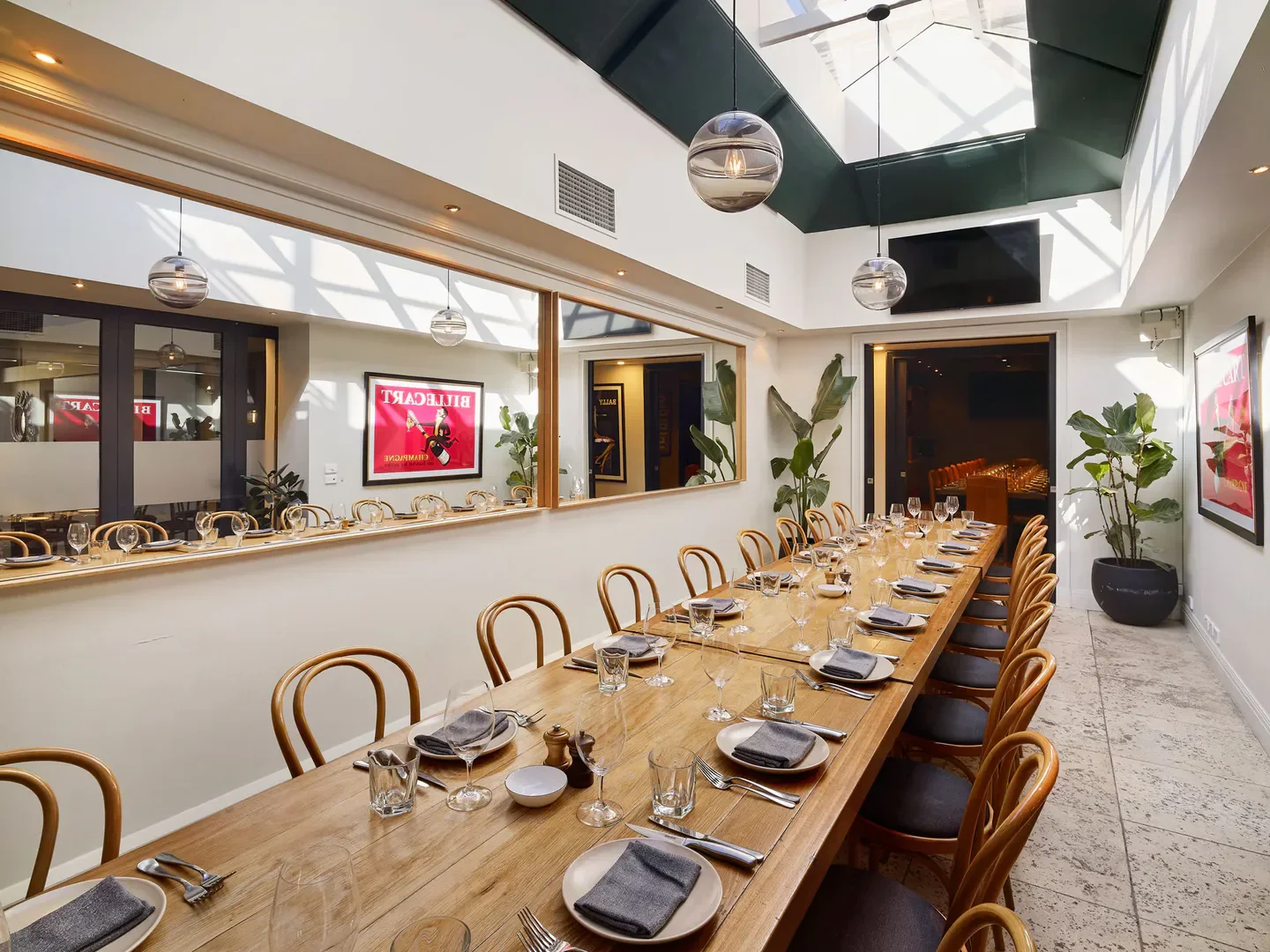 Dining room at Lamaro's Hotel in Melbourne, with a long table and modern decor.