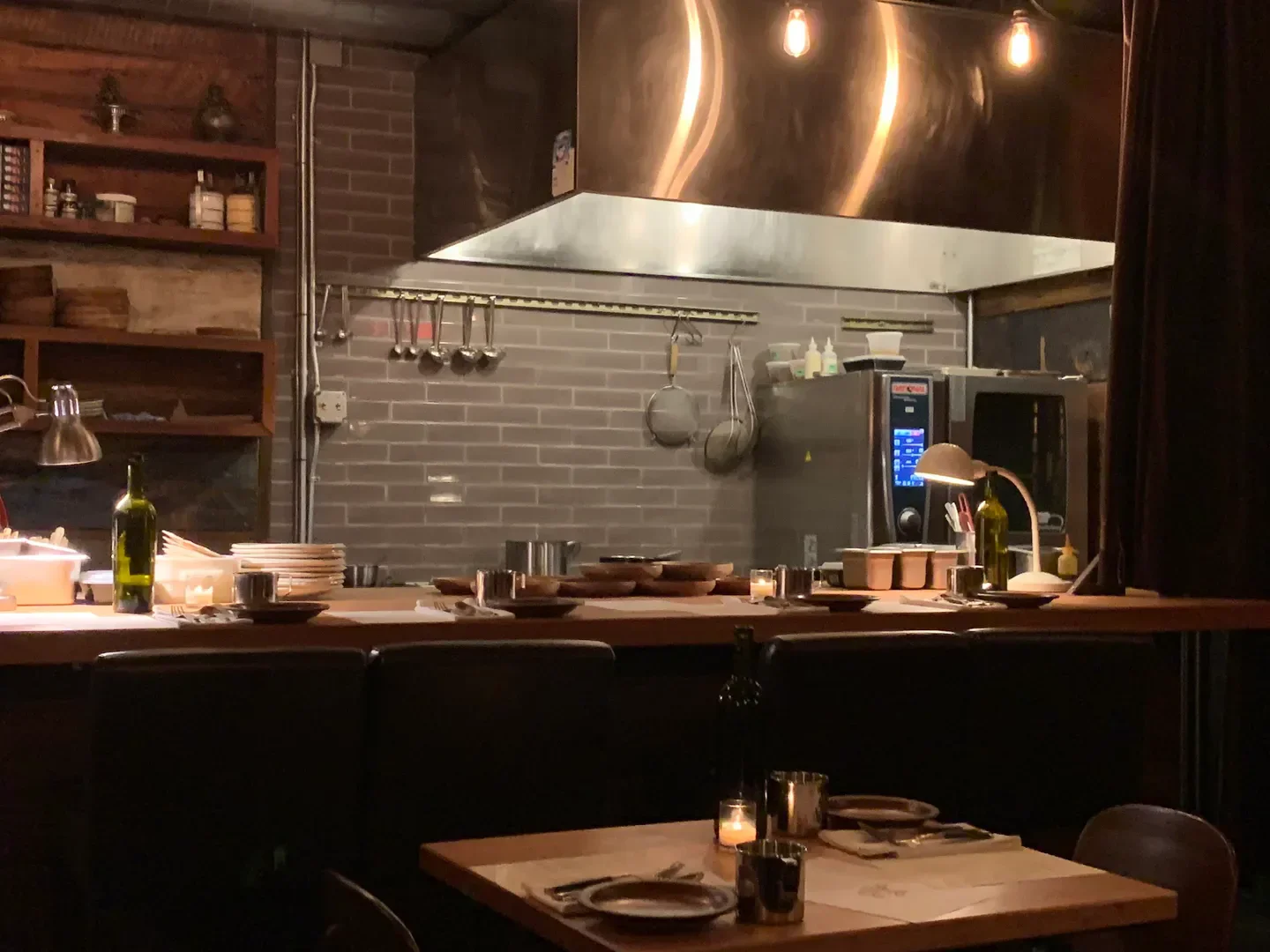 Cozy interior of Langbaan restaurant in Portland, with kitchen and table setting.