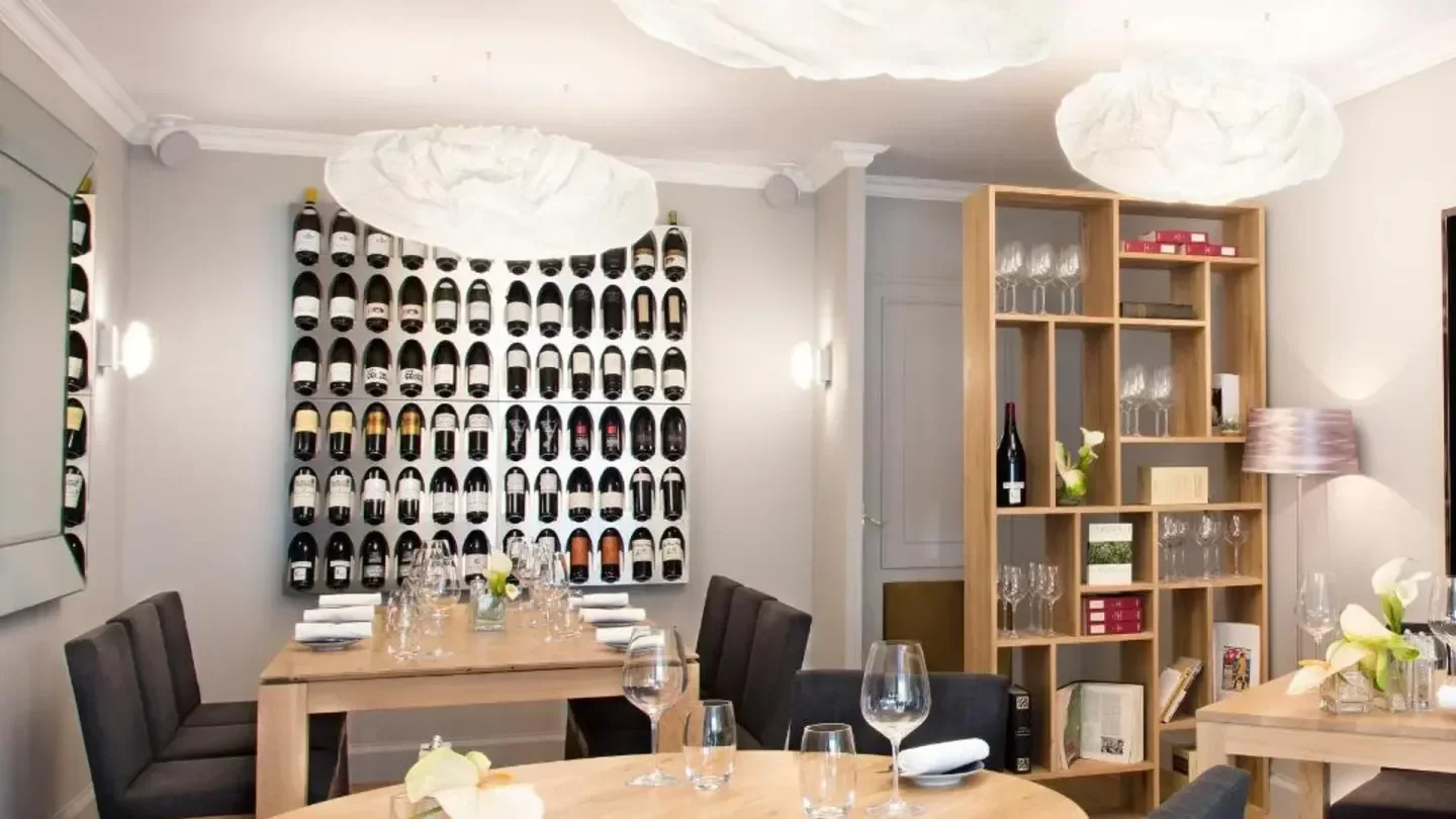 Elegant dining room at L'aparté restaurant in Geneva, with a wine display.