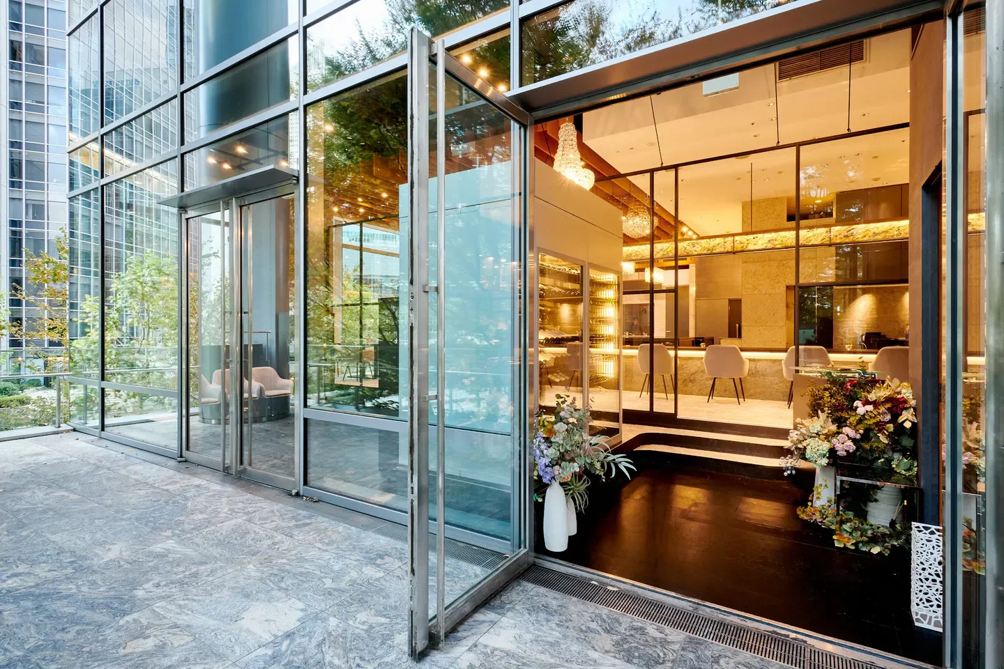 Entrance of L'ARGENT restaurant in Tokyo, showcasing elegant glass doors and interior design.