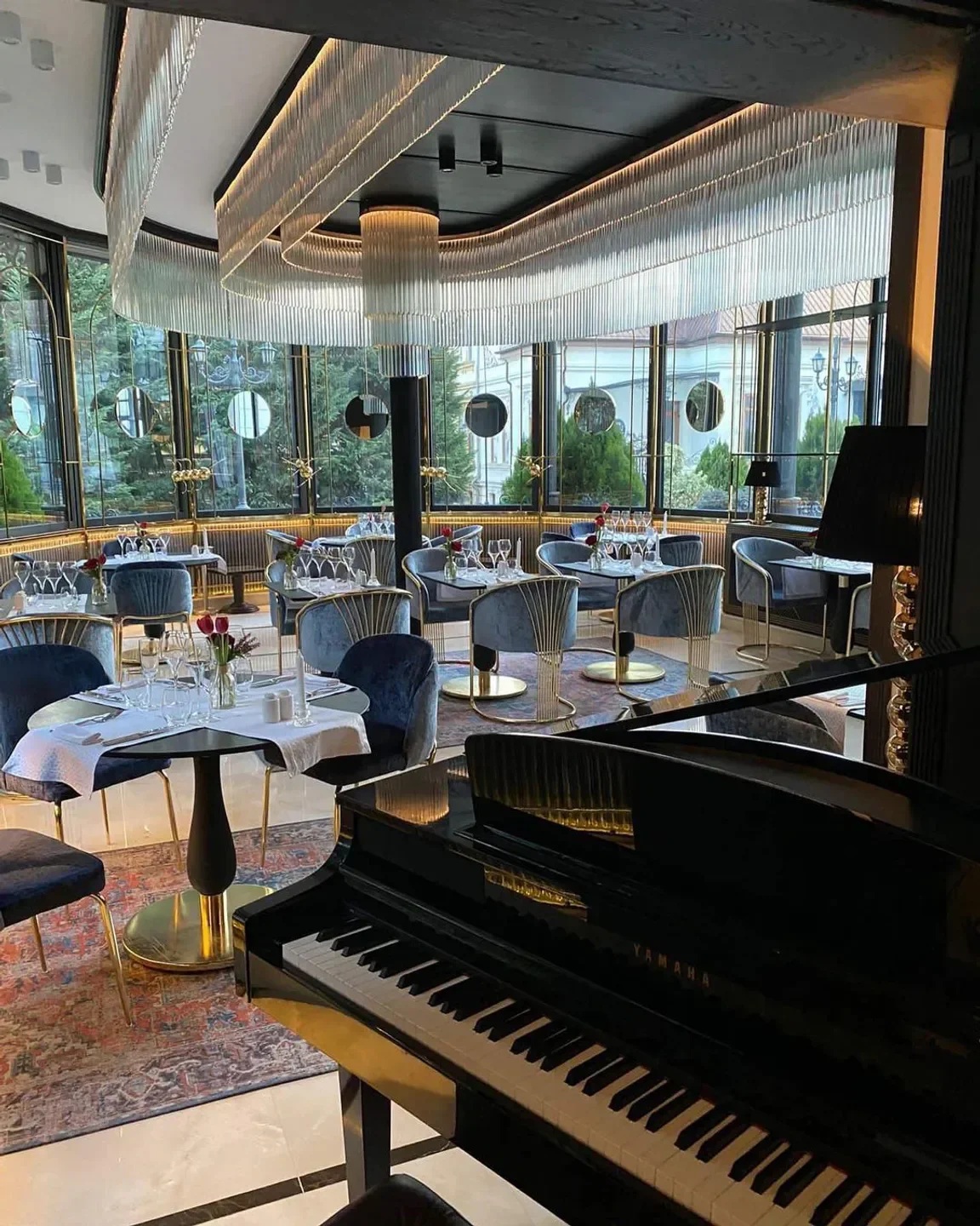 Elegant interior of L’Atelier restaurant in Bucharest featuring piano and dining tables