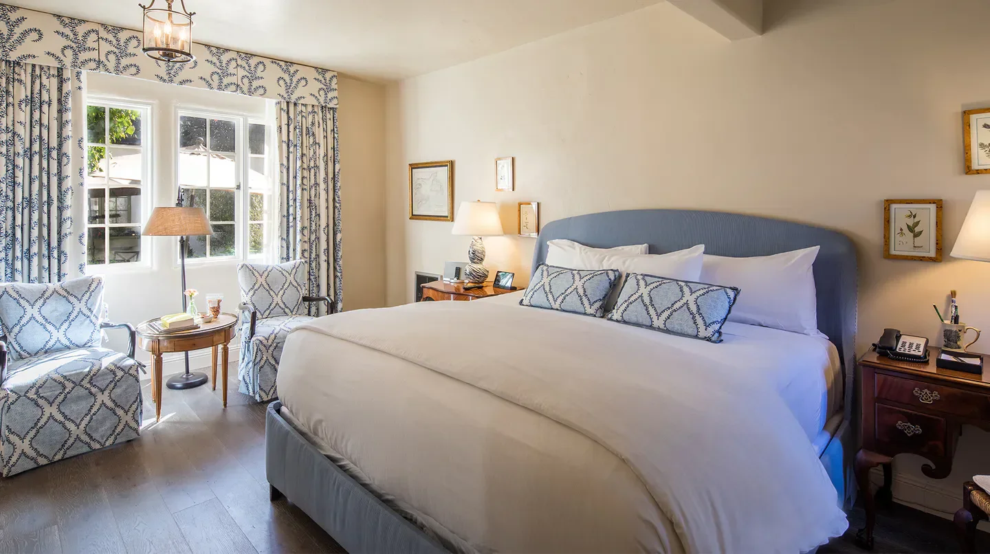 Cozy bedroom at L'Auberge Carmel in Monterey, with elegant decor and comfortable bed.