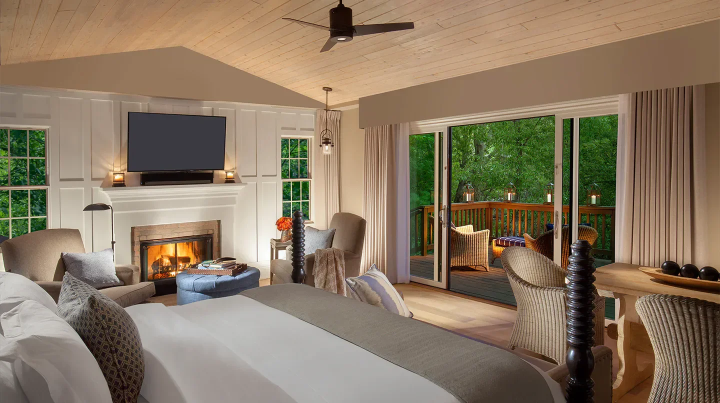 Cozy bedroom at L'Auberge de Sedona with fireplace, overlooking nature in Sedona.