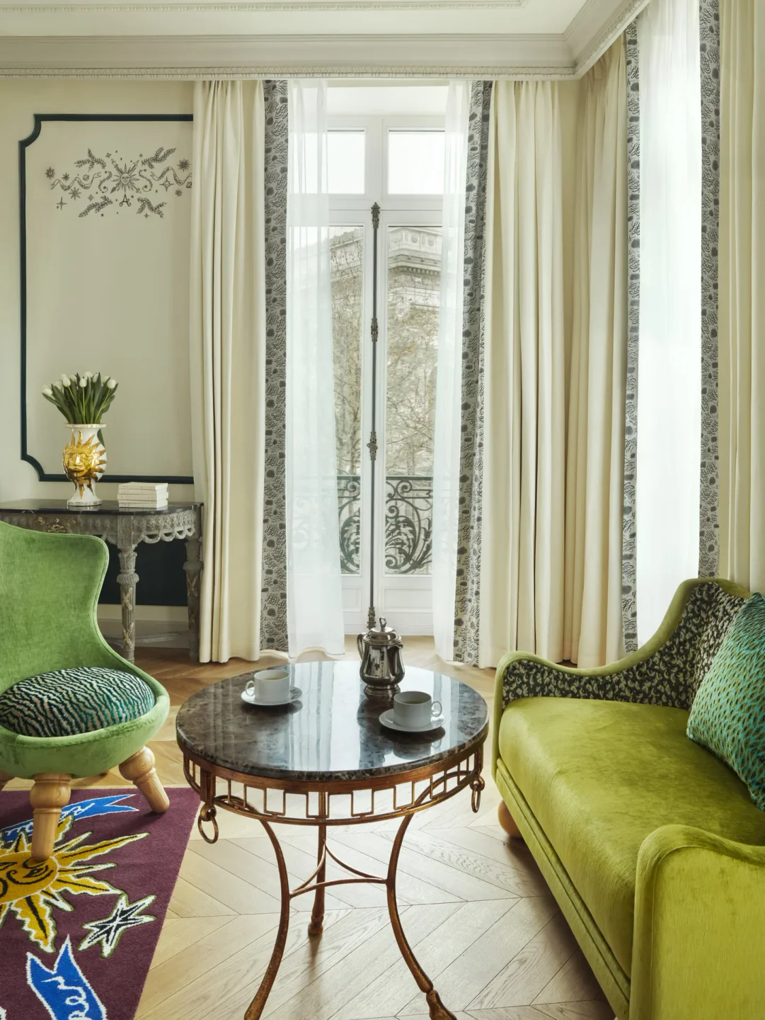 L'Aventure nightclub's chic lounge area with plush green seating and ornate decor, overlooking the city.