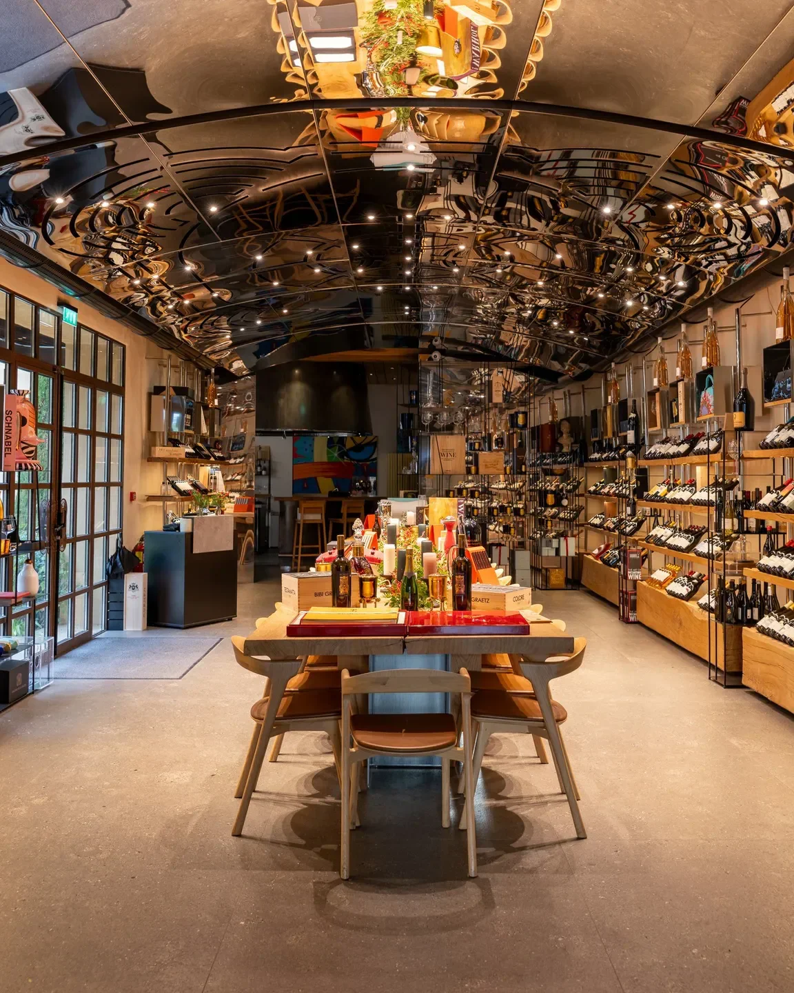 Interior of Le Art in Provence restaurant with mirrored ceiling and wine selection.