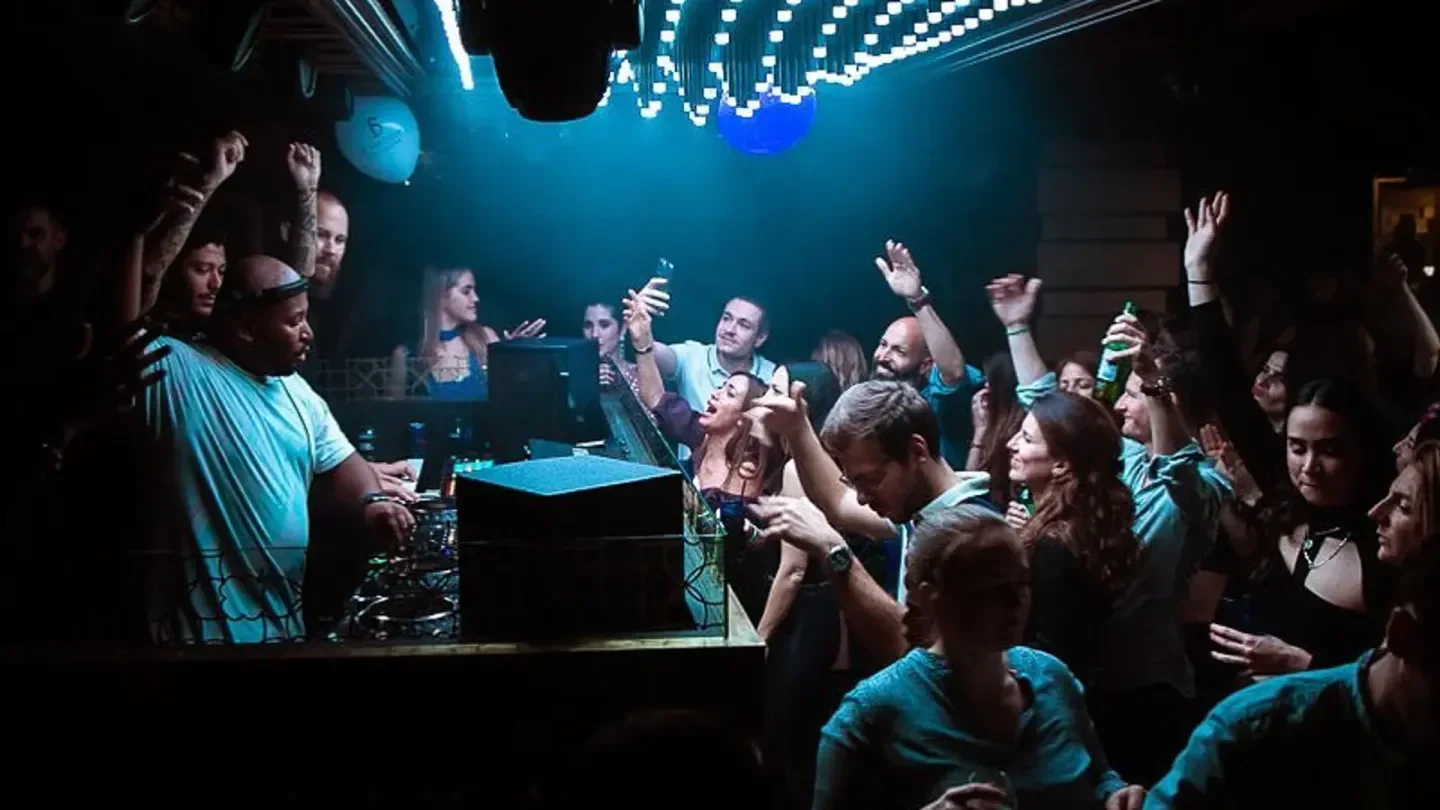 Energetic crowd at Le Baroque nightclub in Geneva enjoying the DJ's music and lights.