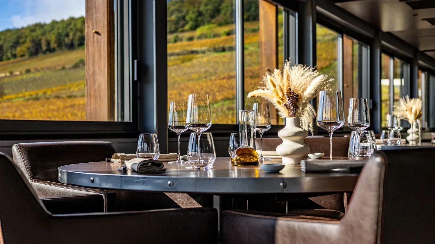 Dining table at Le Charlemagne restaurant in Bourgogne with vineyard views