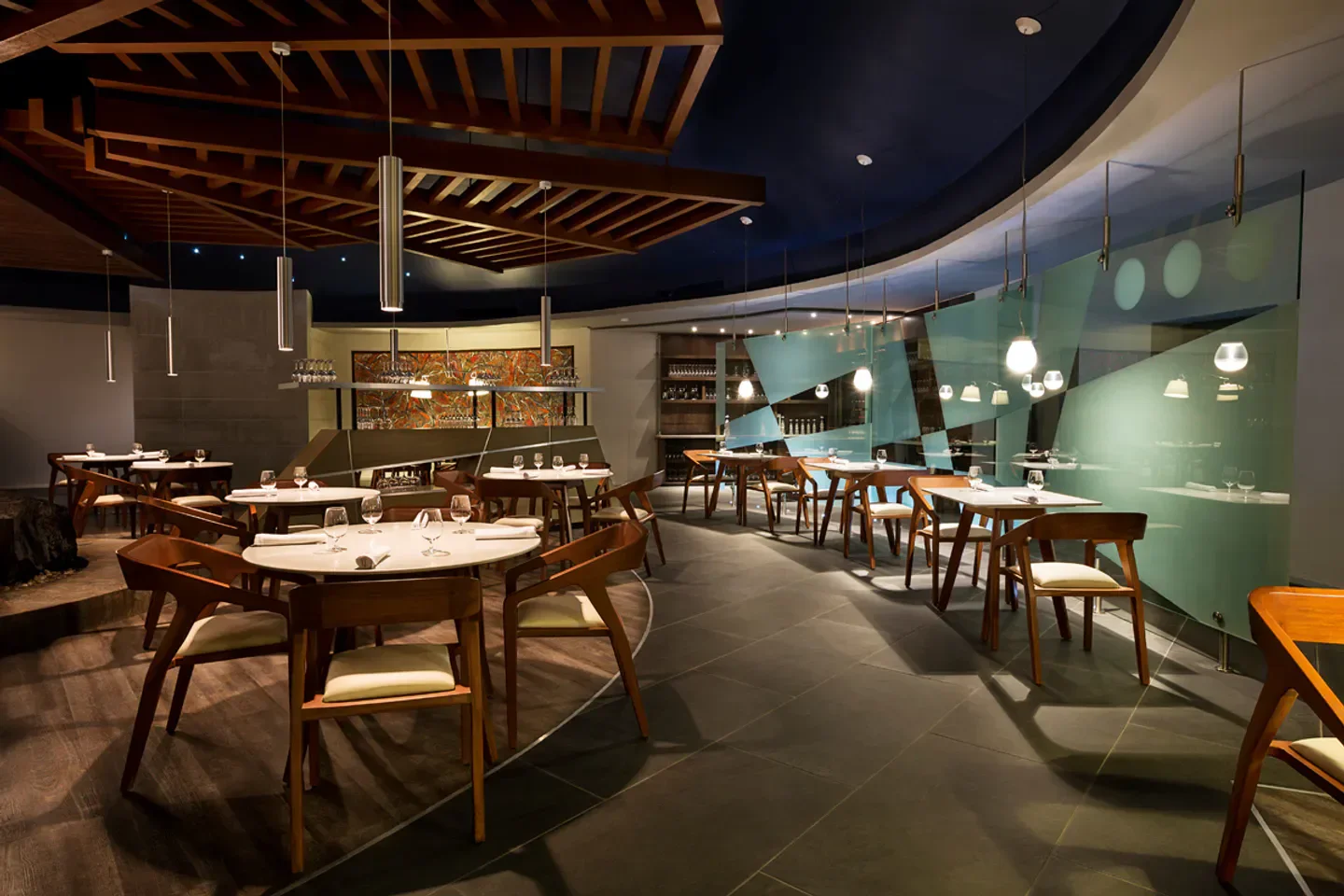 Interior of Le Chique restaurant in Cancun, featuring elegant wooden chairs and tables.