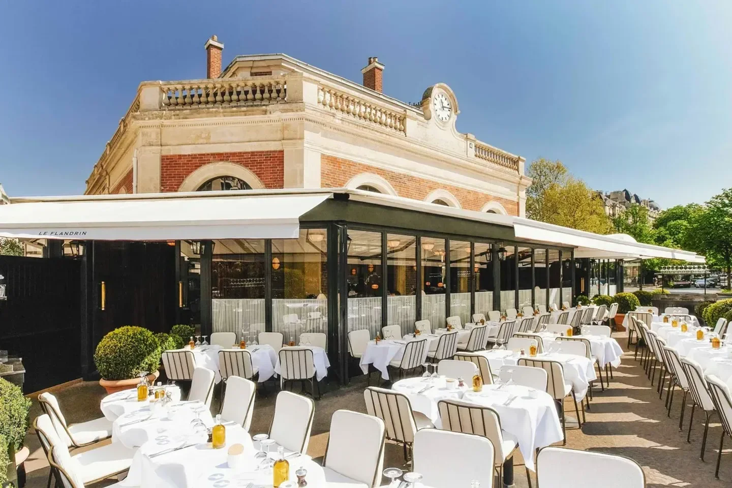 Outdoor seating at Le Flandrin restaurant in Paris, with elegant white table settings.