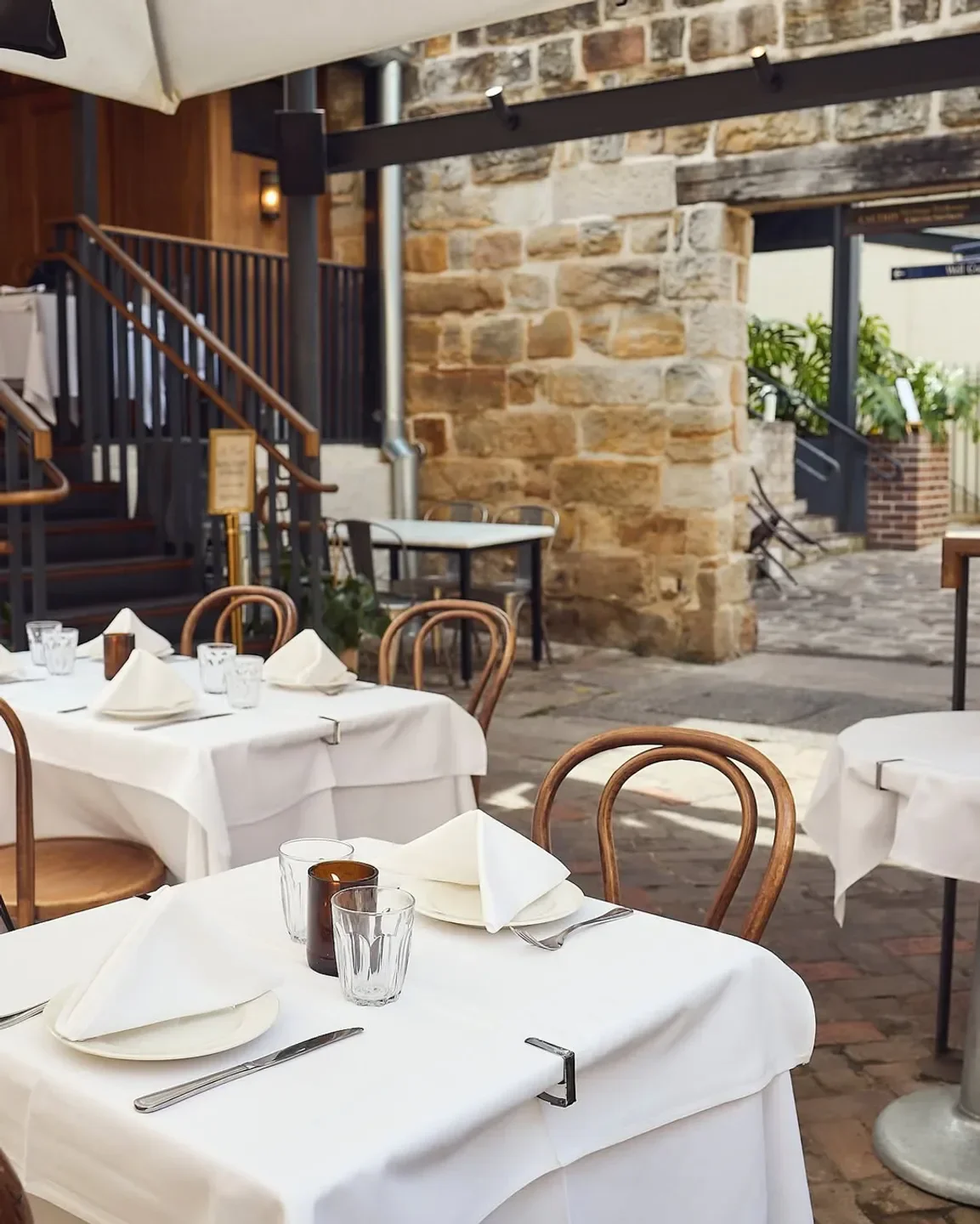 Outdoor dining at Le Foote restaurant in Sydney, set tables with white linens.